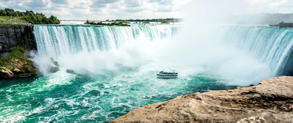 Breathtaking view of Niagara Falls with a sightseeing boat, capturing the grandeur of this iconic landmark.