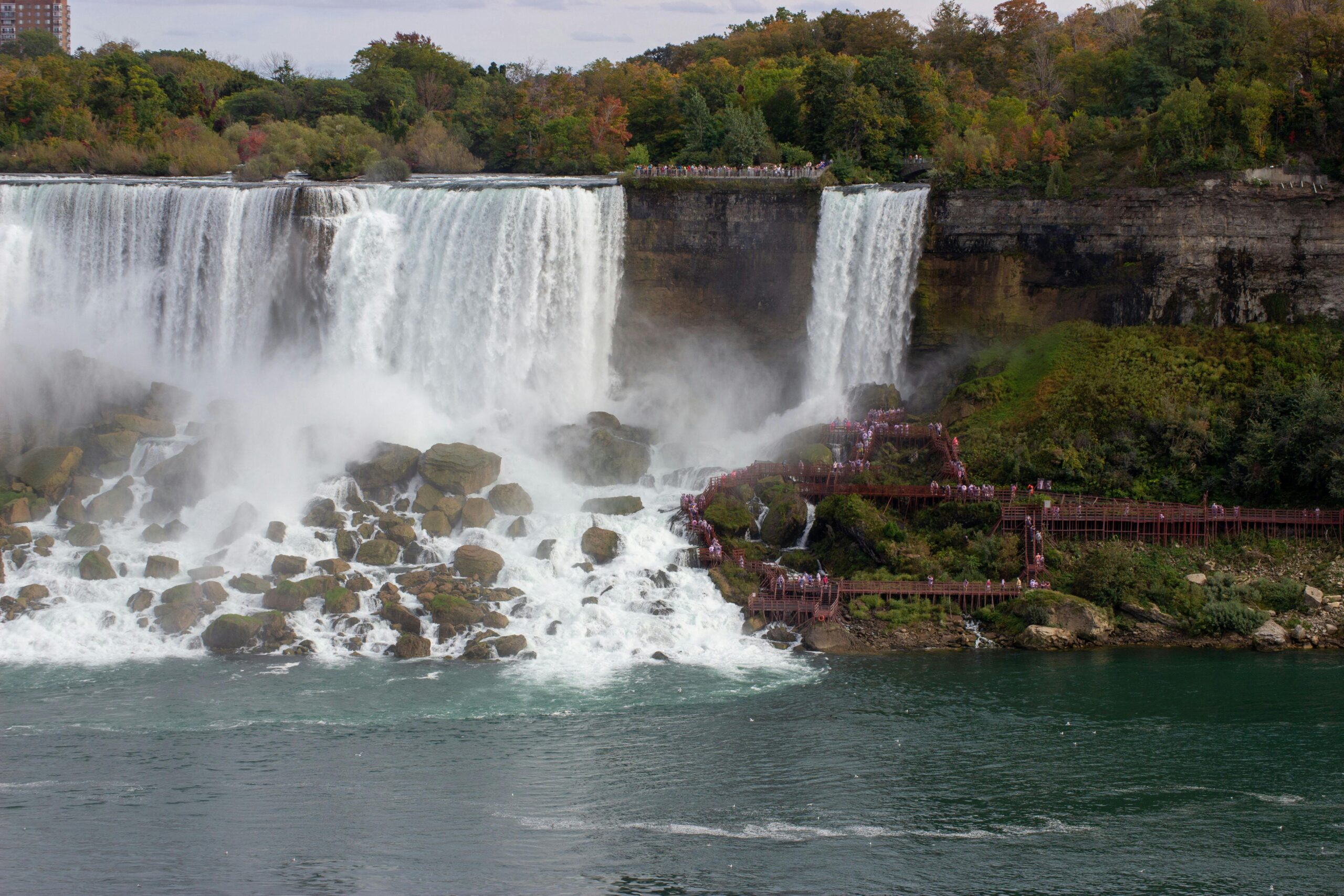 Breathtaking view of Niagara Falls with scenic surroundings and tourists enjoying the sight.