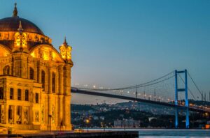 Illuminated Ortaköy Mosque and Bosphorus Bridge overlooking Istanbul's Bosphorus at dusk.