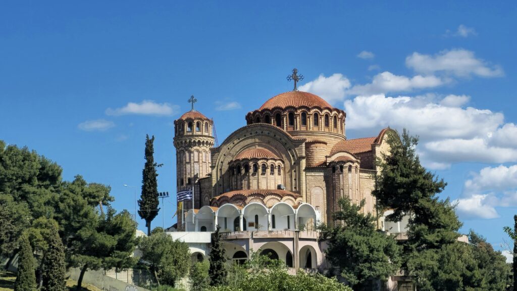 Captivating image of Saint Paul Church in Thessaloniki, under a bright blue sky with lush greenery.