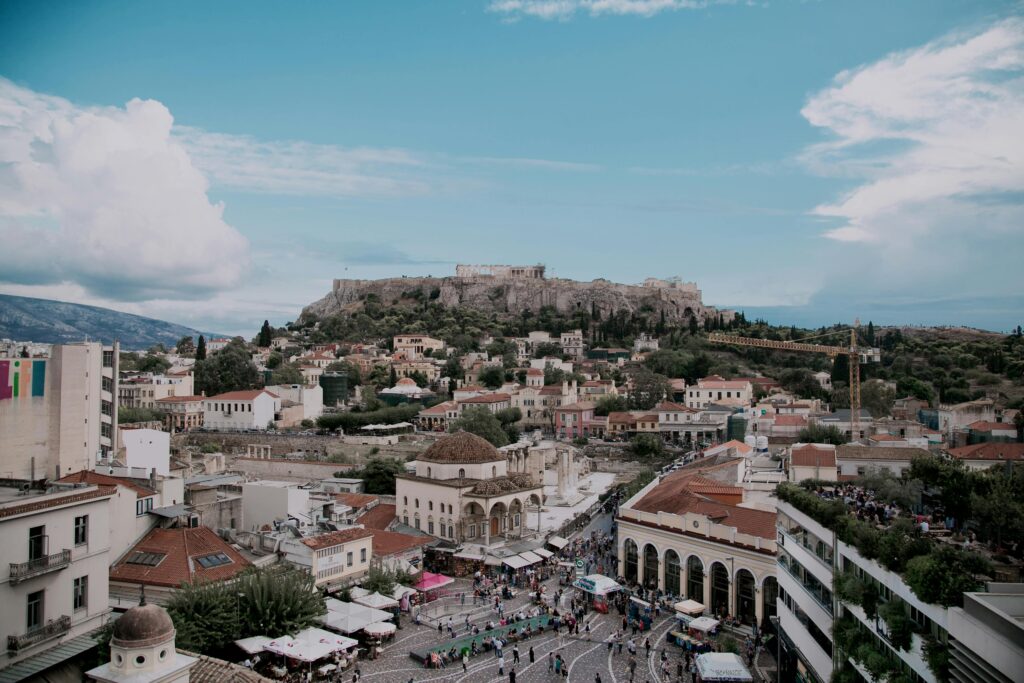 Stunning aerial view of Athens cityscape with iconic Acropolis under blue skies.