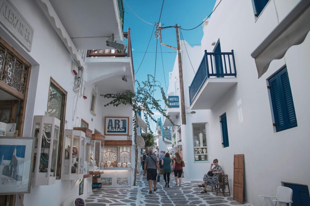 Picturesque street in Mykonos with classic white buildings and vibrant atmosphere.
