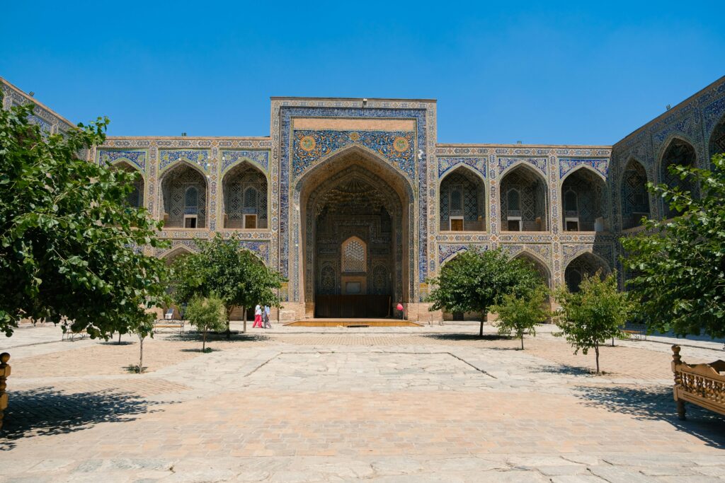 Stunning facade of an Islamic architectural landmark with intricate tilework under a clear blue sky.