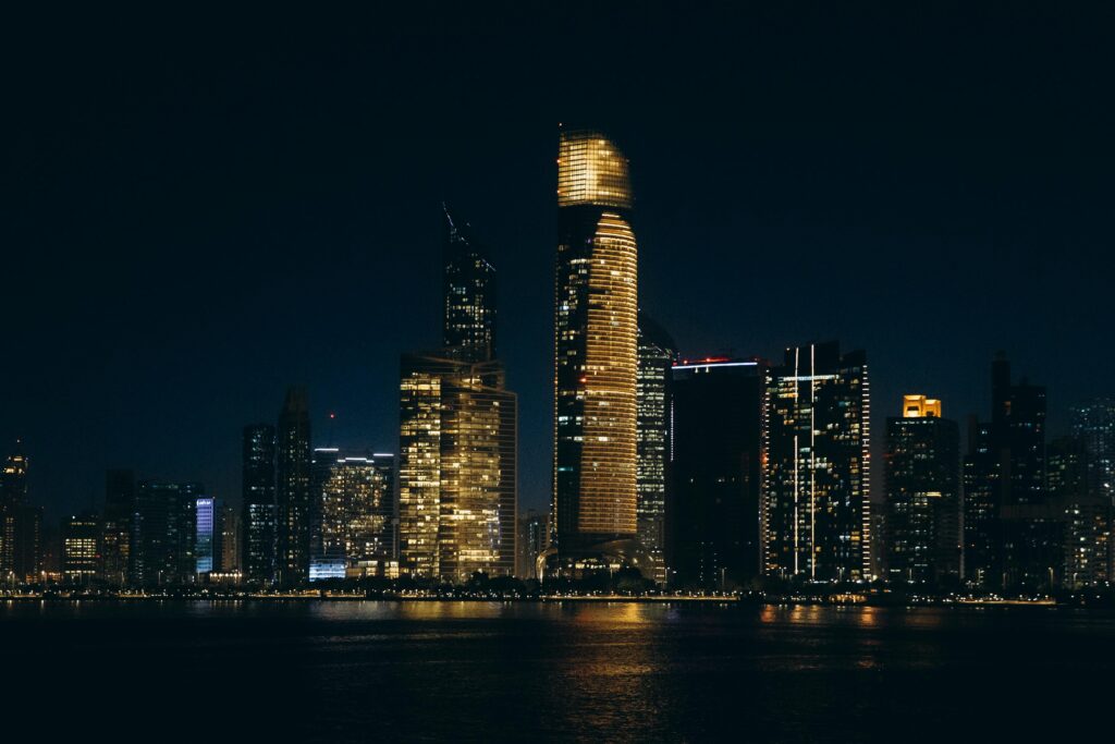 Stunning night view of Abu Dhabi's illuminated skyline reflecting on the water.