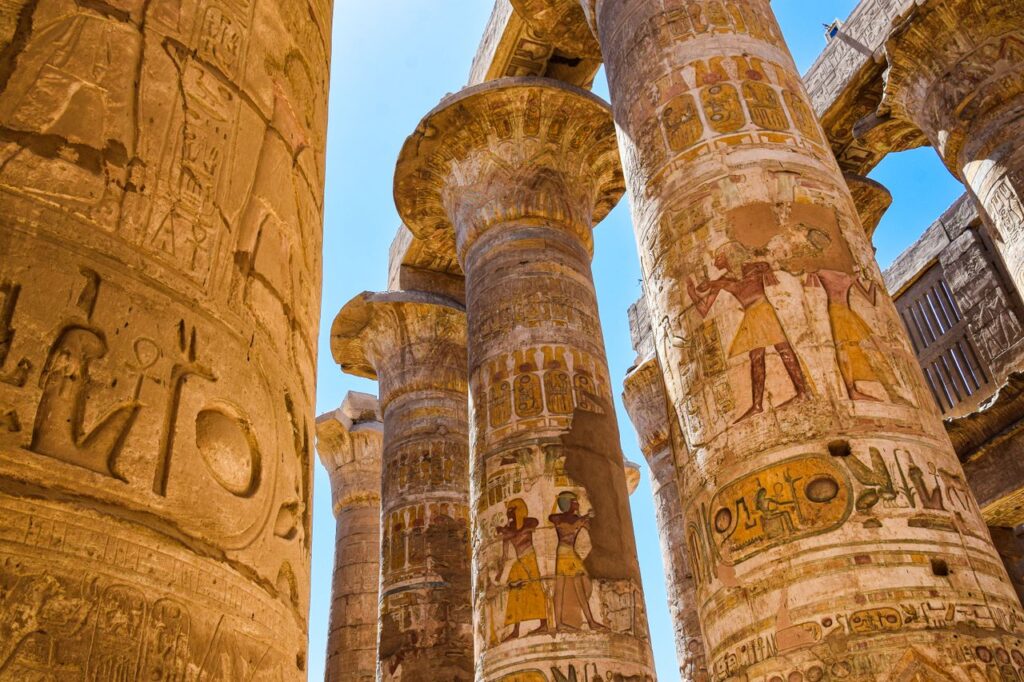 Close-up of ancient Egyptian columns with intricate carvings at Karnak Temple in Luxor.