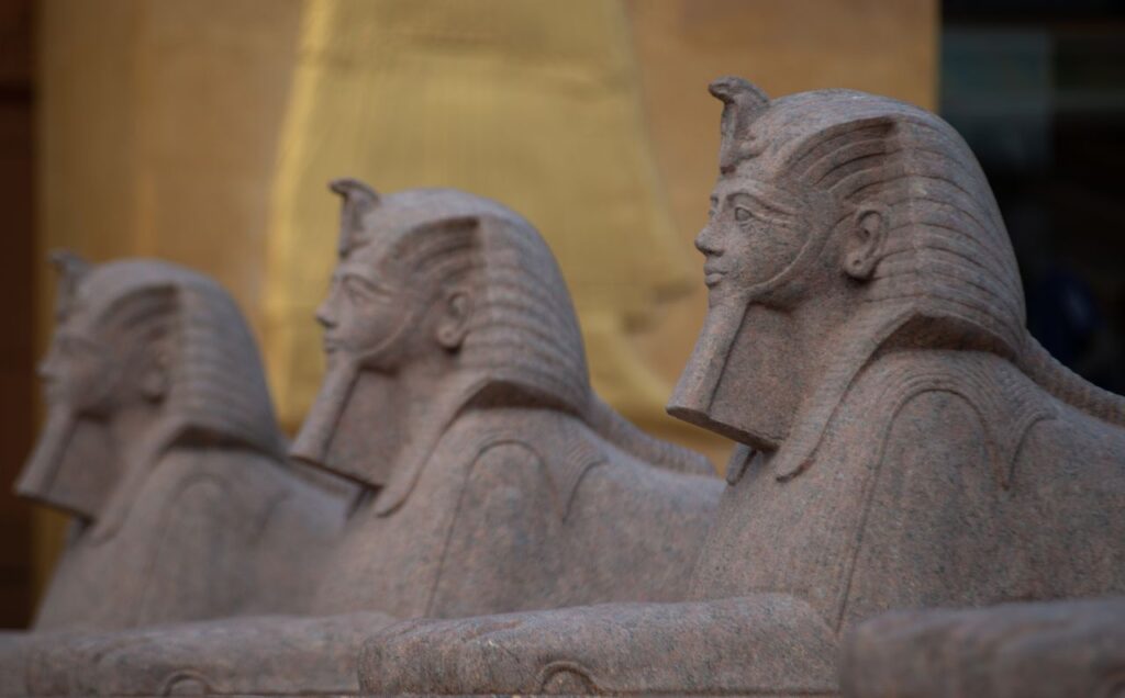 Close-up of stone sphinx statues in ancient Egyptian style, highlighting intricate carvings and details.