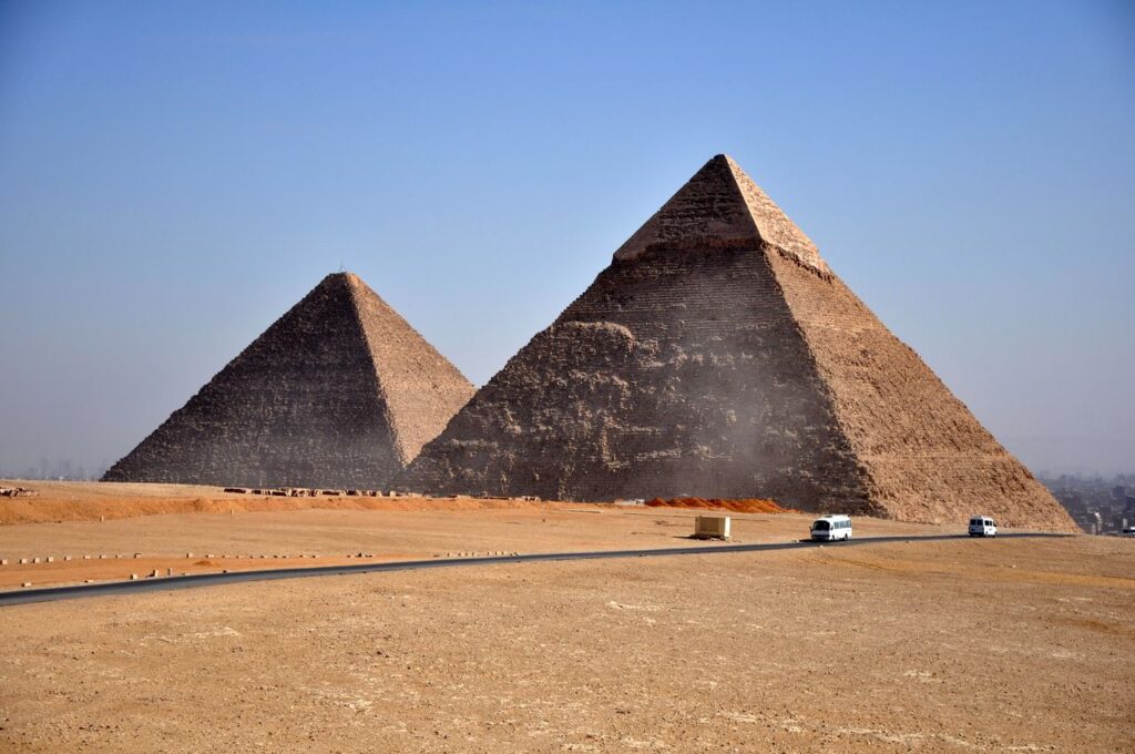 Iconic pyramids of Giza standing under a clear blue sky, showcasing ancient Egyptian architecture.