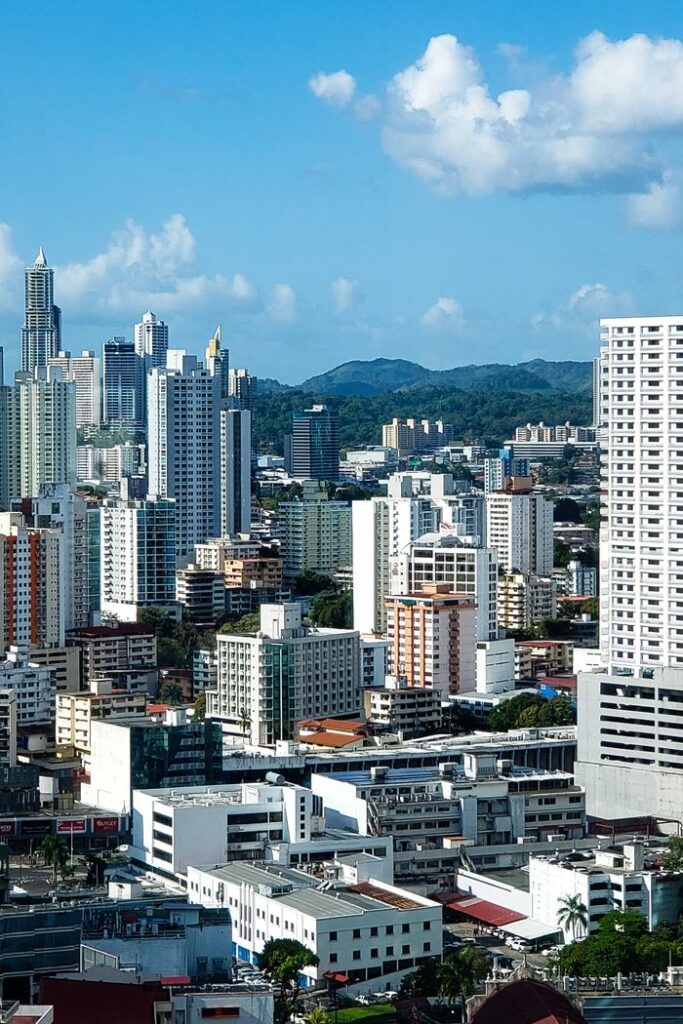 Dynamic aerial view of a bustling city skyline with diverse modern skyscrapers under a clear blue sky.
