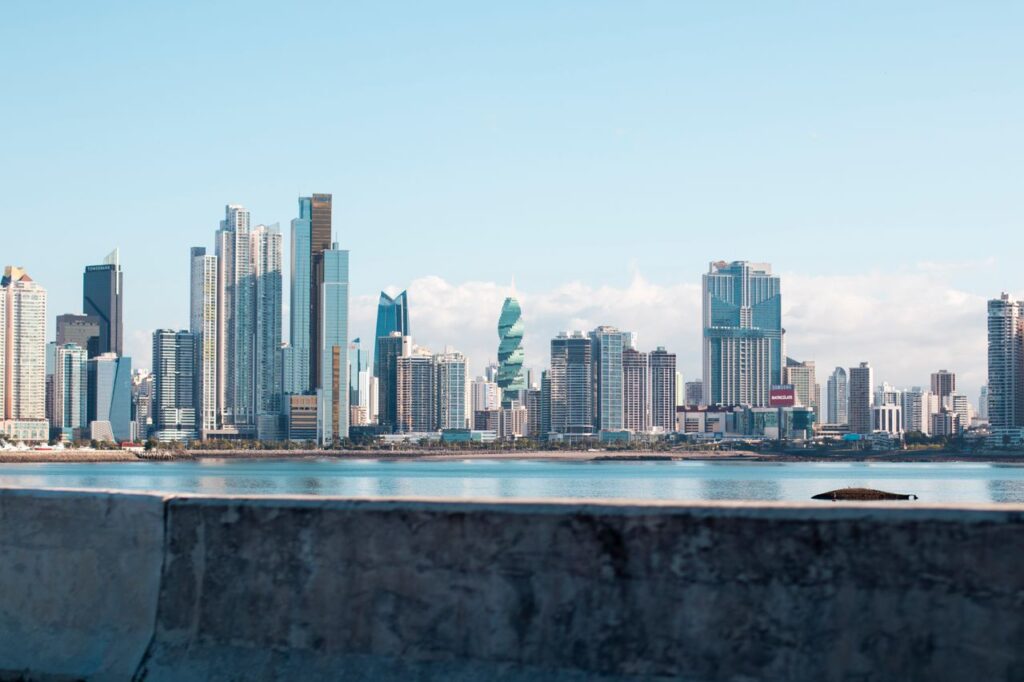 Panama City skyline under clear blue sky, viewed from waterfront showing iconic skyscrapers.