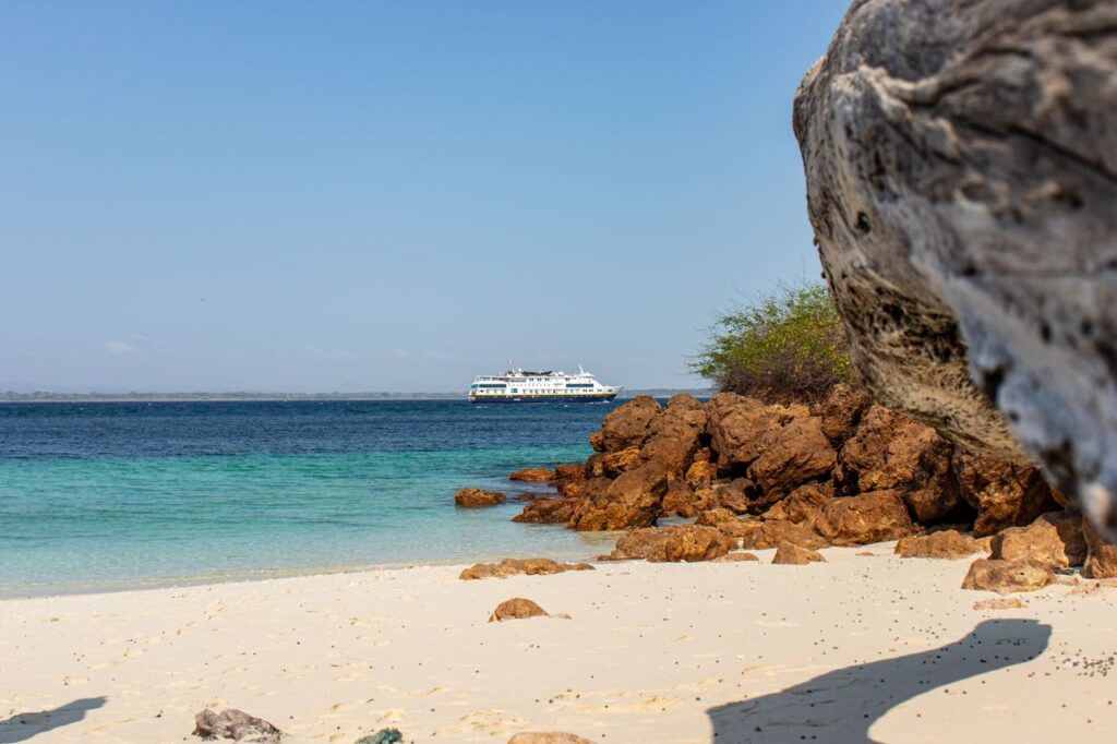 Peaceful Panamanian beach with turquoise waters and a distant ship, perfect for a sunny getaway.