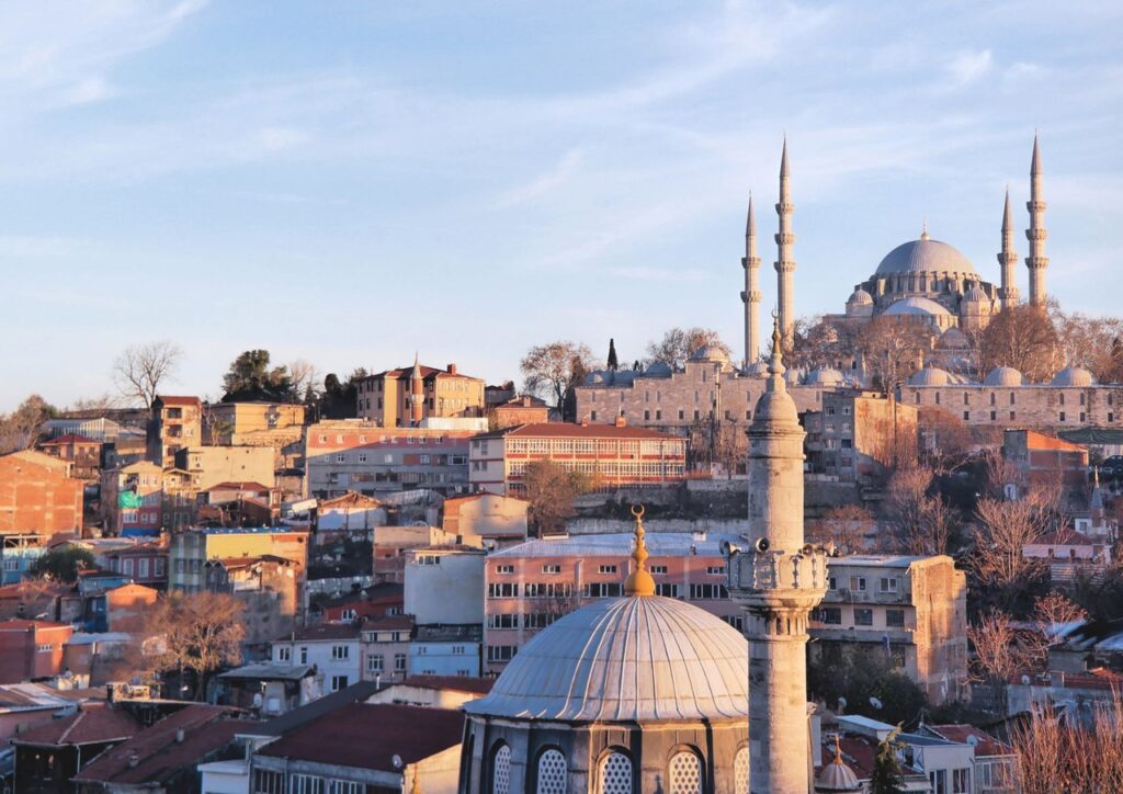 View of the iconic Süleymaniye Mosque and Istanbul's urban landscape at sunset.
